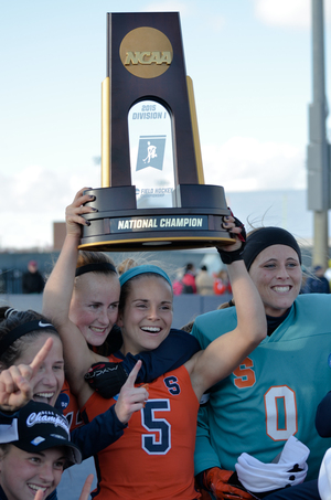 Senior Alyssa Manley raises the NCAA championship trophy, flanked by goalkeeper Jess Jecko and Emma Russell.